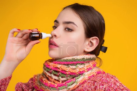 Téléchargez les photos : Le spray nasal. Femme en écharpe en utilisant un spray nasal pour le nez qui coule. Spray nasal pour rhinite allergique, rhume, sinusite. Symptômes de grippe, de virus des sinus ou de maladie. Malade. Le nez rouge. Nasal Le Sinus - en image libre de droit