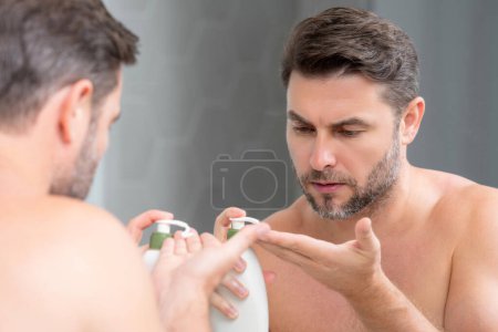 Beauty portrait of hispanic man applying face cream. Skincare cream, skin anti-aging wrinkle effect. Man applying moisturizer cream on skin. Skin care, cosmetic cream treatment for male face