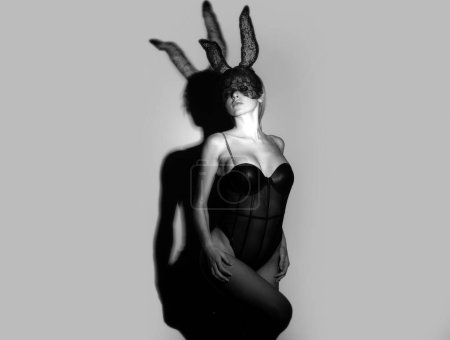 Beautiful dominant mistress girl with fashion dress, bdsm black fetish rabbit mask. Rabbit fashion model in bunny lace mask. Sexy easter