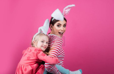 Foto de Hermanas en Pascua. Chicas con orejas de conejo. Caza de huevos. Feliz infancia. Aislado - Imagen libre de derechos