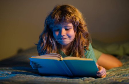 Téléchargez les photos : Des enfants lisant des livres. Enfant lisant un livre au lit avant d'aller dormir. Enfant lisant un livre le soir du coucher. Garçon lecture coucher histoire, conte de fées - en image libre de droit