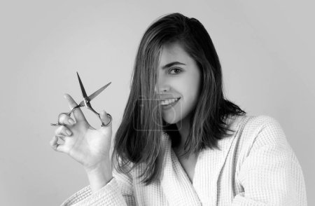 Foto de Cuidado del cabello de las mujeres. Retrato de una joven feliz cortándose el pelo con tijeras - Imagen libre de derechos