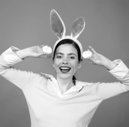 Foto de Conejo de Pascua conejo chica con huevo. Mujer con orejas de conejo. Caza de vacaciones - Imagen libre de derechos