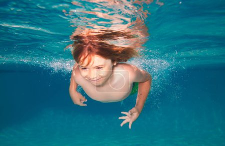 Foto de Niño nadando en la piscina bajo el agua. Niño nadando bajo el agua en el mar. Niños bajo el agua - Imagen libre de derechos