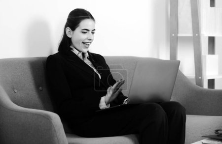 Glücklich lächelnde junge Geschäftsfrau studiert online, schaut Webinar-Podcast auf Laptop-Lernkurs, Online-Konferenzschaltung