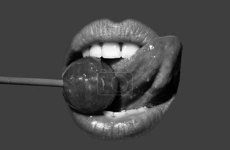 Téléchargez les photos : Orgasm concept. Close up lips with lollipop isolated, sexy blowjob, sensual mouth with lipstick eats sweets. Sexy design for women and girls. Beautiful lips isolated on red - en image libre de droit