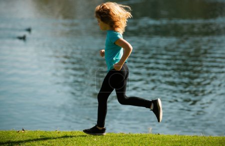 Foto de Child boy running outdoors. Kid running in a summer park - Imagen libre de derechos