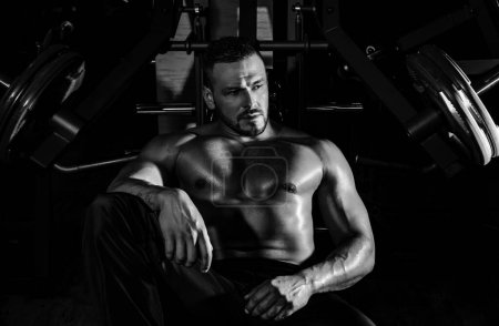 Photo for Tired sporty man resting after training. Man with bottle of water or protein. Athletic guy at gym - Royalty Free Image