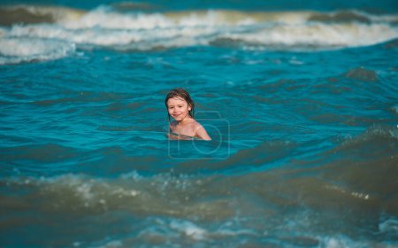Foto de Niño jugando con Olas en el mar azul. Lindo chico divirtiéndose en unas vacaciones de verano en el mar - Imagen libre de derechos