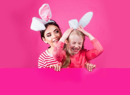 Foto de Chicas de Pascua con orejas de conejo. Hermanita celebra la Pascua. Caza de huevos - Imagen libre de derechos