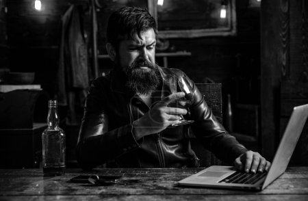 Foto de El barbudo está bebiendo whisky caro. Bebida tradicional de whisky. Hombre con barba sostiene brandy de vidrio - Imagen libre de derechos
