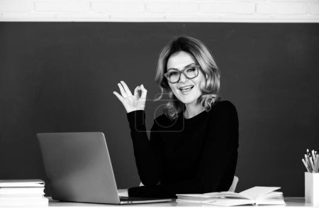 Téléchargez les photos : Portrait d'enseignant drôle étonné ligne d'enseignement des élèves du secondaire avec ordinateur portable dans la salle de classe sur tableau noir - en image libre de droit