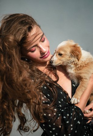 Foto de Mascota. Lindo cachorro con mujer de belleza. Chica modelo de alta moda abrazando con cachorro - Imagen libre de derechos