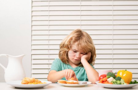 Photo for Portrait of kid with no appetite. Concept of loss of appetite. Child eats organic food. Healthy vegetables with vitamins. Proper kids nutrition concept - Royalty Free Image