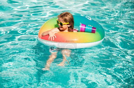 Foto de Vacaciones de verano para niños. Fin de semana de verano. Un chico en la piscina. Niño en el parque acuático. Chico gracioso en círculo de goma inflable - Imagen libre de derechos