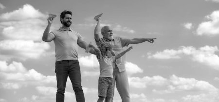 Téléchargez les photos : Trois générations différentes âges grand-père père et enfant fils jouer avec jouet avion à l'extérieur - en image libre de droit