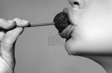 Téléchargez les photos : Close up lips with lollipop isolated, sexy blowjob, sensual mouth with lipstick eats sweets. Sexy design for women and girls. Beautiful lips - en image libre de droit