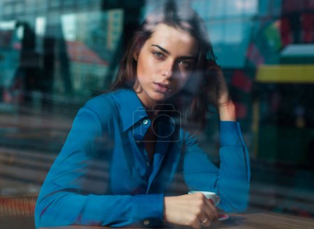 Foto de Concepto pensativo. Mujer en un café mientras mira a través del cristal de la ventana - Imagen libre de derechos