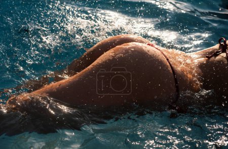 Foto de Summer vacation. Sexy woman ass buttocks. Girl in bikini on sea water background with copyspace. Sexy buttocks - Imagen libre de derechos