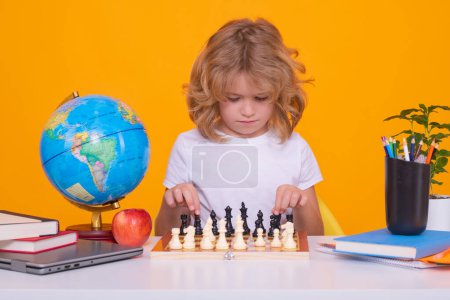 Photo for Child with chess on yellow isolated studio background. Little kid play chess. Thinking child. Chess game for kids. Intelligent, smart and clever school boy - Royalty Free Image