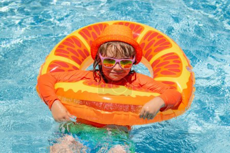 Photo for Little child boy in swimming pool with inflatable toy ring. Kids swim on summer vacation. Swim for child on float. Beach sea and water fun - Royalty Free Image