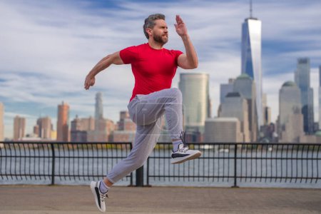 Téléchargez les photos : Un coureur. Sport sain. Un homme qui court à New York. Un coureur de fitness fait du jogging près de Manhattan. Le type qui court dans la rue américaine. Un homme en tenue de sport à New York. Vêtements de sport pour coureurs - en image libre de droit