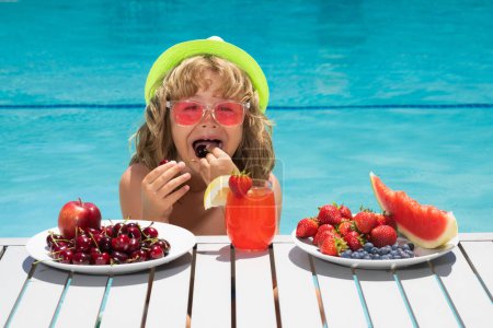 Photo for Healthy food. Outdoor leisure activity with kids by swimming pool. Summertime. Summer cocktail and fruits. Happy child having fun at swimming pool on summer day. Kids summer holidays and vacation - Royalty Free Image