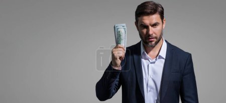 Mann hält Bargeld in Dollarnoten vor isoliertem grauen Hintergrund. Studioporträt eines Geschäftsmannes mit einem Bündel Dollarnoten. Dollar-Geld-Konzept. Karriere-Vermögensgeschäft. Cash-Dollar-Banner