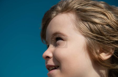 Foto de Retrato de un niño mirando hacia el cielo azul con espacio para copiar, cara de cerca. Cabeza disparar niños retrato - Imagen libre de derechos