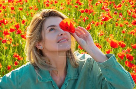 Photo for Woman in a field of red poppies enjoys nature. A young woman in a poppy field. Spring girl - Royalty Free Image