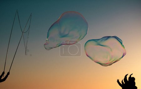 Photo for Big soap bubbles in sunset. Giant soap bubble. Flying soap bubbles on sky blue background at sunset - Royalty Free Image