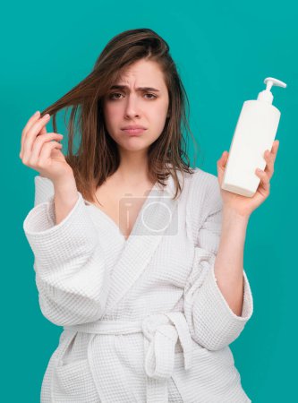 Téléchargez les photos : Femme tenir bouteille shampooing et revitalisant. Femme problème de perte de cheveux pour shampooing de soins de santé, après la douche. Concept de perte de cheveux - en image libre de droit