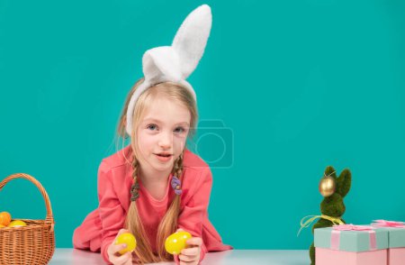 Foto de Chica de Pascua con huevos de color. Concepto festivo de primavera. Niño feliz en orejas de conejo en vacaciones - Imagen libre de derechos
