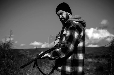 Photo for Hunter with shotgun gun on hunt. Hunting without borders. Clothes for the hunter. Close up Portrait of hamdsome Hunter - Royalty Free Image