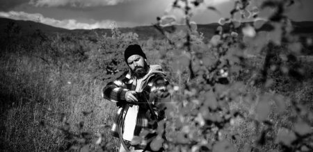 Foto de Hunter con una mochila y una pistola de caza en el bosque de otoño. Hunter con escopeta a la caza. Curso de Educación de Seguridad Hunter - Imagen libre de derechos