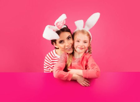 Foto de Chicas felices con orejas de conejo. Hermanita celebra la Pascua. Caza de huevos - Imagen libre de derechos