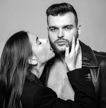Photo for Touch his bristle. Girlfriend passionate red lips and man leather jacket. She adores male beard. Passionate hug. Passionate couple in love. Man brutal well groomed macho and attractive girl cuddling. - Royalty Free Image