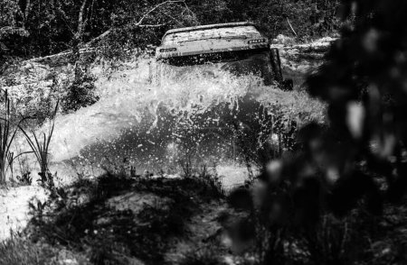 Photo for Off-road travel on mountain road. Offroad vehicle coming out of a mud hole hazard. Drag racing car burns rubber. Extreme. Off-road car. Rally racing - Royalty Free Image