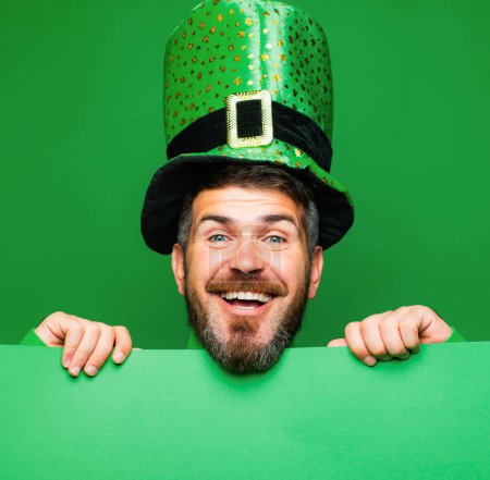 Foto de El día de Lucky Patricks. El hombre sobre fondo verde celebra el Día de San Patricio. Hombre en Saint Patricks Día duende sombrero de fiesta que se divierten en el fondo verde. Copiar espacio - Imagen libre de derechos