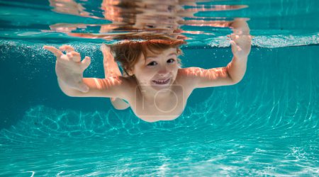 Foto de Divertido retrato facial de niño nadando y buceando bajo el agua con diversión en la piscina - Imagen libre de derechos