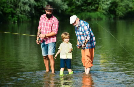 Little boy on a lake with his father and grandfather. Great-grandfather and great-grandson. Father teaching his son fishing against view of river and landscape