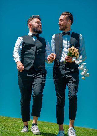 Foto de Boda de pareja gay. Feliz pareja gay caminando, tomados de la mano. amante gay macho pareja - Imagen libre de derechos