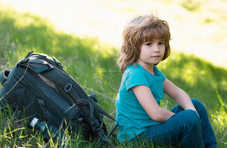 Téléchargez les photos : Enfants assis dans l'herbe haute et admirant les belles vues sur les montagnes et la nature, un petit garçon et une petite fille sur la pelouse, la chaîne de montagnes et le fond de la forêt. - en image libre de droit