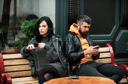 Téléchargez les photos : Jeune couple assis après une bagarre. Triste femme après une dispute avec son petit ami. Couple en colère s'ignorant, problèmes relationnels - en image libre de droit