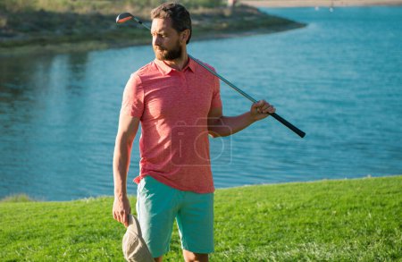 Téléchargez les photos : Joueur de golf masculin sur un terrain de golf professionnel. Portrait de golfeur homme avec club de golf - en image libre de droit