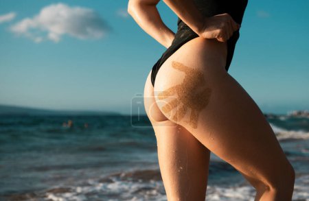 Foto de Sexy summer ass, butt, buttocks with hand prints on beach - Imagen libre de derechos