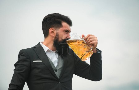 Foto de Hombre de traje clásico bebiendo cerveza. Retrato del hombre con gran taza de cerveza - Imagen libre de derechos