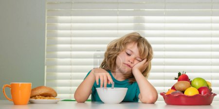 Photo for Portrait of kid with no appetite. Concept of loss of appetite. Schoolchild eating breakfast before school. - Royalty Free Image