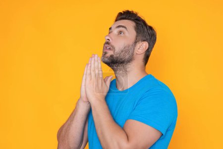 Photo for Man praying. Isolated portrait of male pray. Guy thinking intensely. Man having put hands together in prayer or meditation, looking calm. Praying man hoping for better. Asking God for good luck - Royalty Free Image