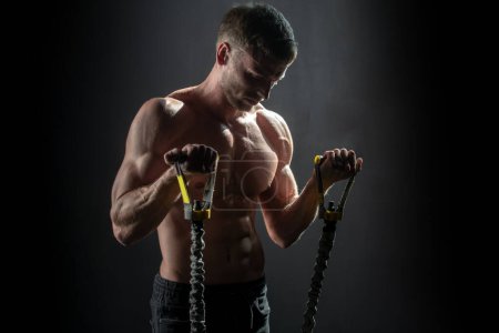 Photo for Sport Man exercising suspension training trx. Sexy muscular man doing suspension training. Sport. Men training with fitness trx straps in the gym. Guy exercising her muscles sling or suspension straps - Royalty Free Image